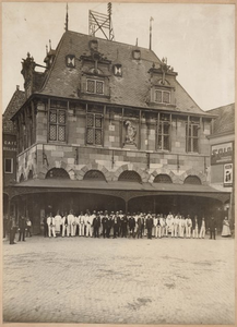 foto-L18 Kaashandelaren en kaasdragers staande voor het Waaggebouw aan de Rode Steen, ca. 1900