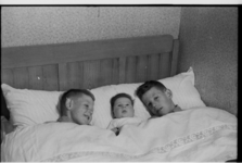 590 Drie kinderen Zegel in een bed onder de dekens